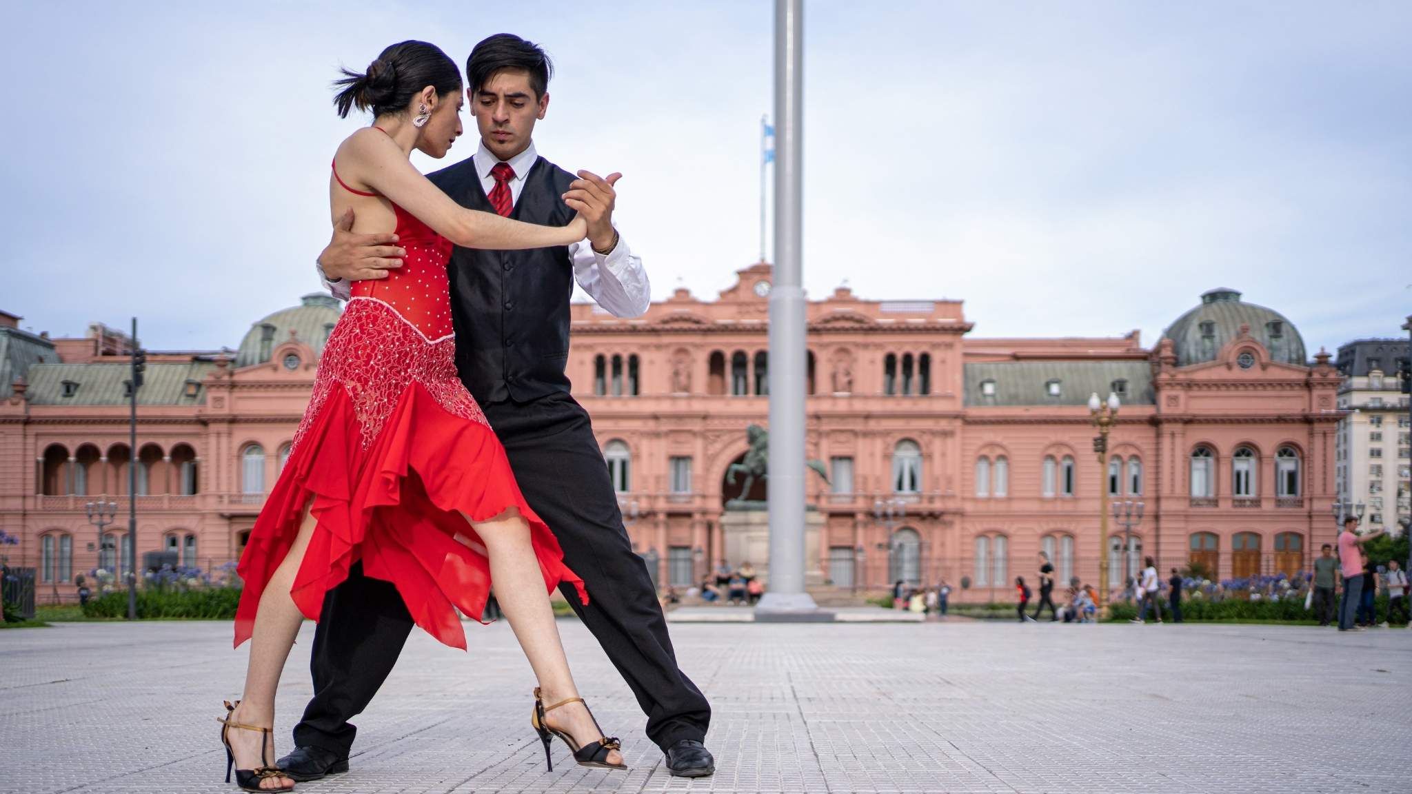 A couple dancing tango on the street of Buenos Aires in front of Casa Rosada.