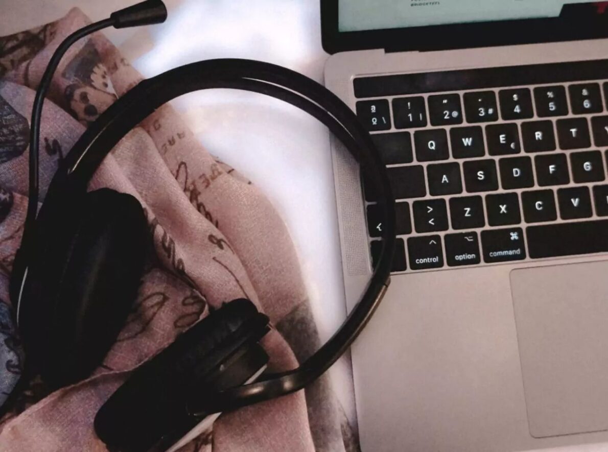 A headset sits on a laptop.