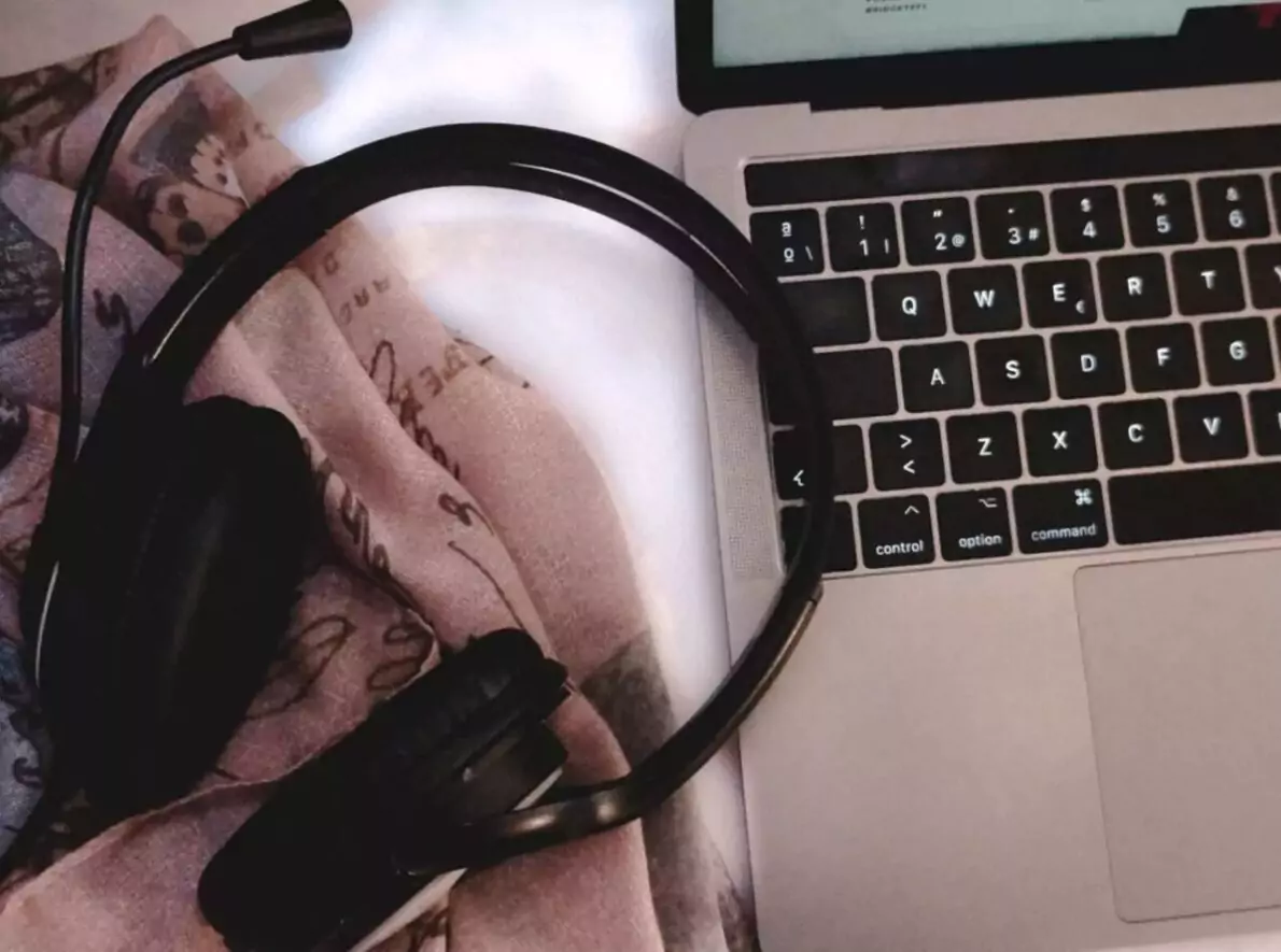 A headset sits on a laptop.