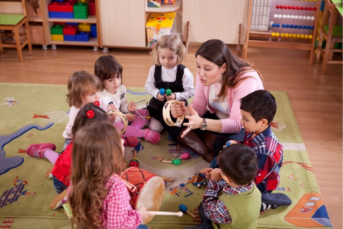 A teacher plays instruments with young learners in class
