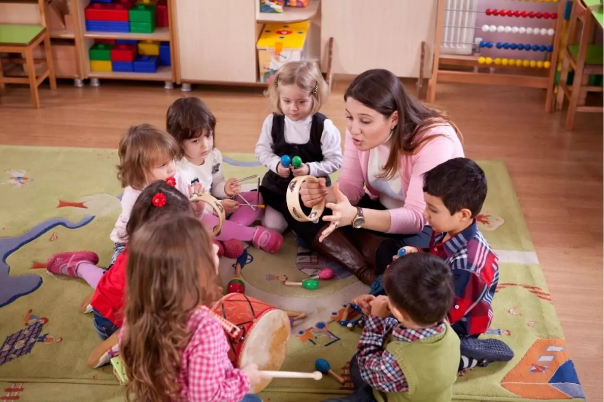A teacher plays instruments with young learners in class