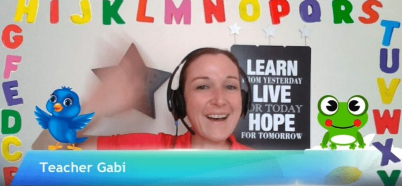 Bridge grad Gabrielle, teaching online and displaying her background to teach young learners.