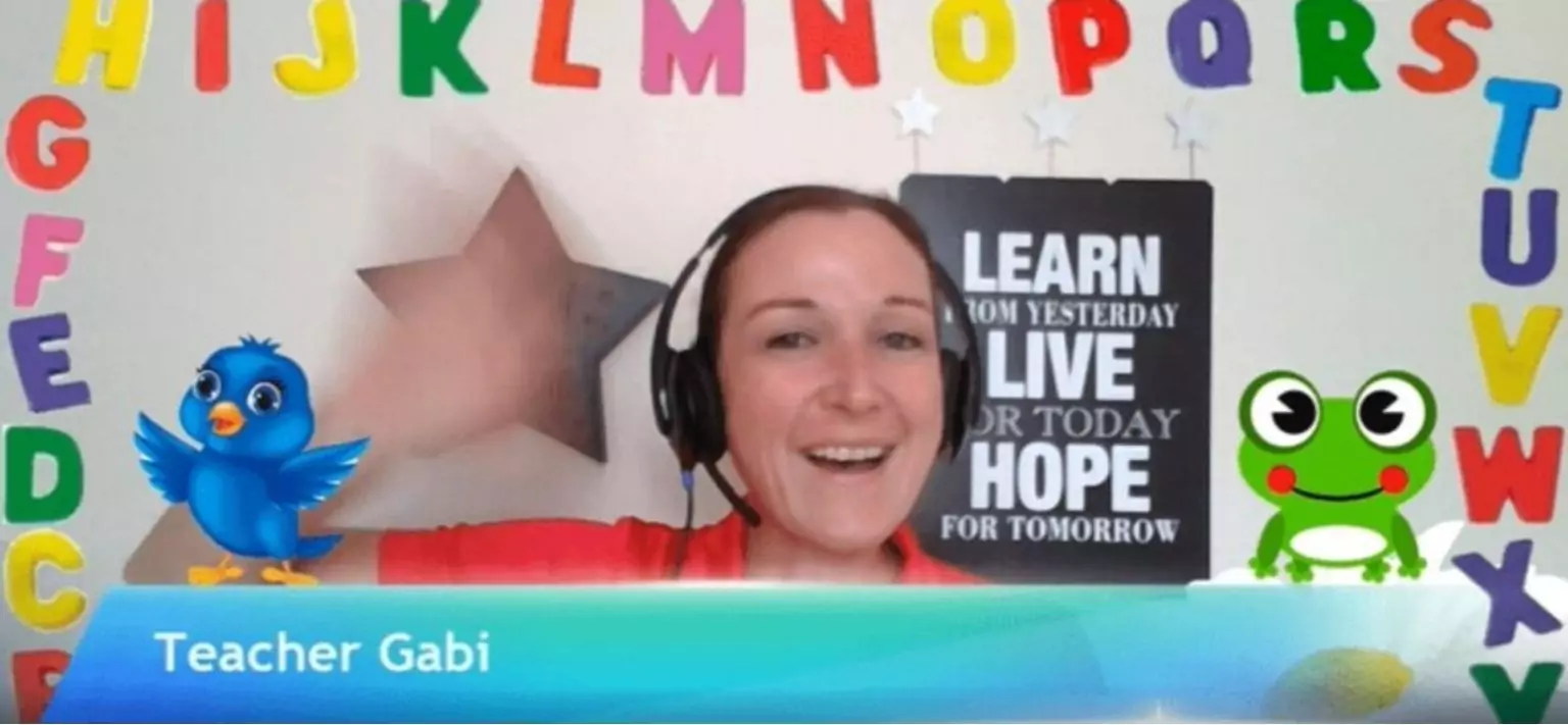 Bridge grad Gabrielle, teaching online and displaying her background to teach young learners.