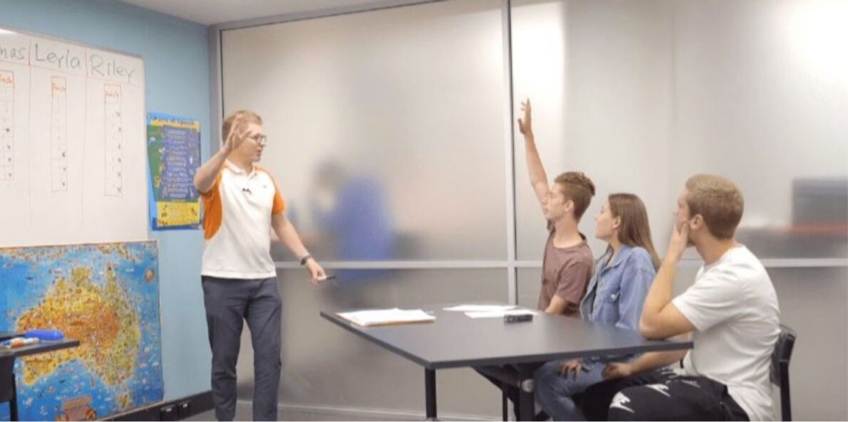Teacher in class eliciting answers from students

