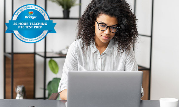 Woman with glasses on a laptop with Bridge 20-hour Teaching PTE Test Prep certification badge