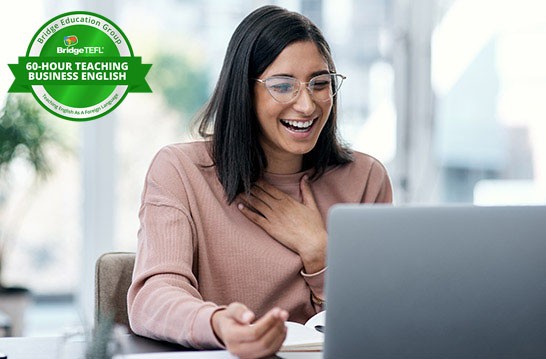 Professional smiling at a laptop with Bridge 60-hour Teaching Business English certification badge