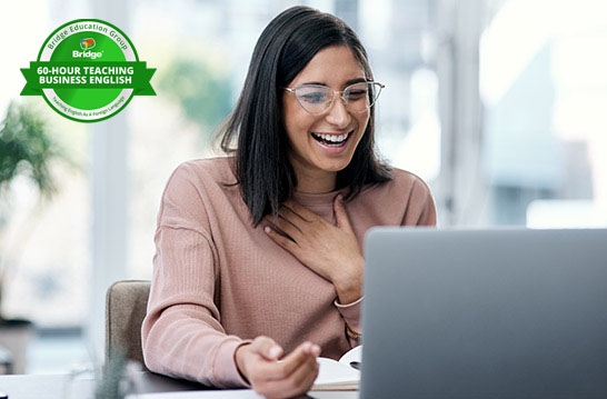 Professional smiling at a laptop with Bridge 60-hour Teaching Business English certification badge