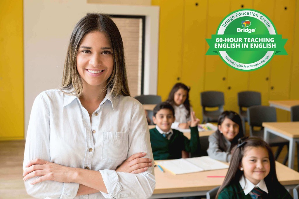 Smiling teacher in a classroom with Bridge 60-hour Teaching English in English certification badge