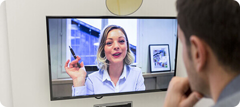 Teacher reviewing an online English class on a computer monitor